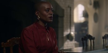 Movie still from “The Haunting of Bly Manor” (2020), directed by E.L. Katz – A woman in a red shirt is sitting down; Close Up shot, Over the shoulder angle