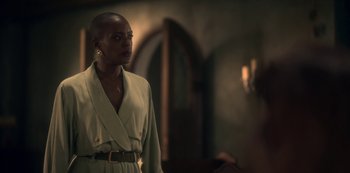 Movie still from “The Haunting of Bly Manor” (2020), directed by E.L. Katz – A woman in a robe stands next to a wall; Medium shot, Over the shoulder angle