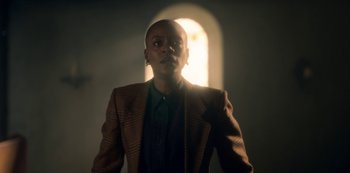 Movie still from “The Haunting of Bly Manor” (2020), directed by E.L. Katz – A man in a jacket and a jacket is looking at the camera; Medium shot, Low angle