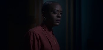 Movie still from “The Haunting of Bly Manor” (2020), directed by E.L. Katz – A woman in a red shirt is standing in the dark; Close Up shot, Over the shoulder angle