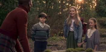 Movie still from “The Haunting of Bly Manor” (2020), directed by E.L. Katz – A young boy and a young girl standing next to each other in the woods; Medium shot, Over the shoulder angle