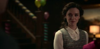 Movie still from “The Haunting of Bly Manor” (2020), directed by E.L. Katz – A woman standing in front of balloons in a dark room; Close Up shot, Over the shoulder angle