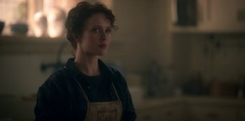 Movie still from “The Haunting of Bly Manor” (2020), directed by E.L. Katz – A woman in a kitchen wearing an apron; Close Up shot, Over the shoulder angle