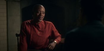 Movie still from “The Haunting of Bly Manor” (2020), directed by E.L. Katz – A woman in a red shirt is sitting in front of a microphone; Medium shot, Over the shoulder angle