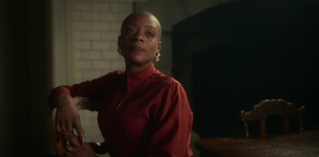 A woman in a red shirt is standing in a room