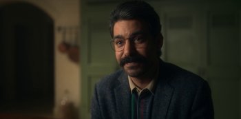 Movie still from “The Haunting of Bly Manor” (2020), directed by E.L. Katz – A person wearing glasses and a suit; Close Up shot, Over the shoulder angle