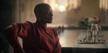 A woman in a red shirt sitting at a table