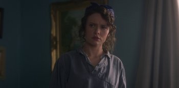 Movie still from “The Haunting of Bly Manor” (2020), directed by E.L. Katz – A young woman with a bow in her hair stands in front of a mirror; Close Up shot, Over the shoulder angle