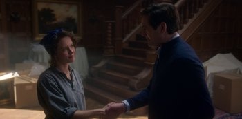 Movie still from “The Haunting of Bly Manor” (2020), directed by E.L. Katz – A man and a woman shaking hands in a room; Medium shot, Over the shoulder angle