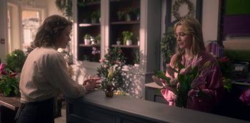 Movie still from “The Haunting of Bly Manor” (2020), directed by E.L. Katz – Two women are standing at a counter and one is using a cell phone; Medium shot, Over the shoulder angle