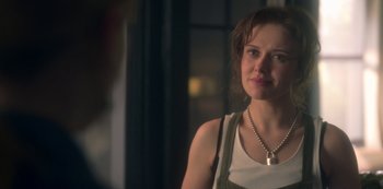 Movie still from “The Haunting of Bly Manor” (2020), directed by E.L. Katz – A young woman wearing a white tank top and a necklace; Close Up shot, Over the shoulder angle