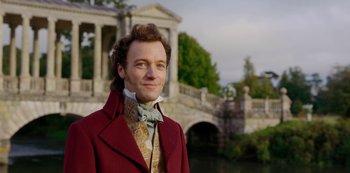 Movie still from “Bridgerton” (2020), created by Chris Van Dusen – A man in a red coat standing in front of a bridge; Close Up shot, Over the shoulder angle