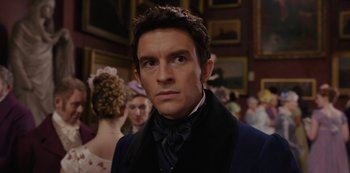 Movie still from “Bridgerton” (2020), created by Chris Van Dusen – A person wearing a suit and tie; Close Up shot, Over the shoulder angle