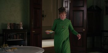 Movie still from “Bridgerton” (2020), created by Chris Van Dusen – A woman in a green dress is holding a plate; Medium shot, High angle