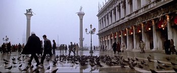 Movie still from “The Italian Job” (2003), directed by F. Gary Gray – A group of people walking on the sidewalk near a street lamp; Extreme Wide shot, Low angle