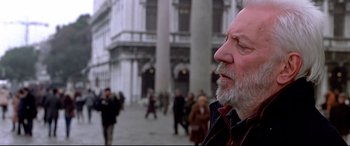 Movie still from “The Italian Job” (2003), directed by F. Gary Gray – An older man with a gray beard is walking down the street; Close Up shot, Low angle