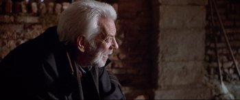 Movie still from “The Italian Job” (2003), directed by F. Gary Gray – An older man with white hair looking to his left; Close Up shot, Over the shoulder angle