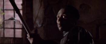 Movie still from “The Italian Job” (2003), directed by F. Gary Gray – A person wearing a suit and holding a gun; Close Up shot, Low angle