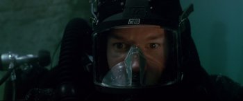 Movie still from “The Italian Job” (2003), directed by F. Gary Gray – A man wearing a helmet and a gas mask in the dark; Close Up shot, Overhead angle