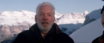 Movie still from “The Italian Job” (2003), directed by F. Gary Gray – An older man with white hair is posing for a picture; Close Up shot, Low angle