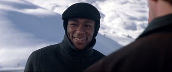 Movie still from “The Italian Job” (2003), directed by F. Gary Gray – A man wearing a black hat and a gray jacket; Close Up shot, Over the shoulder angle