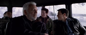 Movie still from “The Italian Job” (2003), directed by F. Gary Gray – A man with white hair sitting next to two other men; Medium shot, Over the shoulder angle
