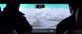 Movie still from “The Italian Job” (2003), directed by F. Gary Gray – A view from a car of a snowy road with cars driving on it; Wide shot, Over the shoulder angle