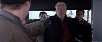 Movie still from “The Italian Job” (2003), directed by F. Gary Gray – A man with a gun in his hand and another man in the back of a car; Medium shot, Over the shoulder angle