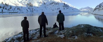 Movie still from “The Italian Job” (2003), directed by F. Gary Gray – Two men standing on a hill overlooking a lake; Extreme Wide shot, High angle