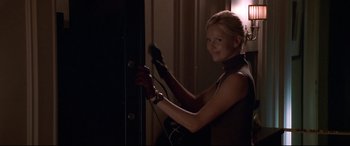 Movie still from “The Italian Job” (2003), directed by F. Gary Gray – A woman holding a blow dryer in a room; Medium shot, Low angle
