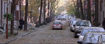 Movie still from “The Italian Job” (2003), directed by F. Gary Gray – A street filled with lots of parked cars on the side of the road; Extreme Wide shot, High angle