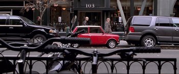 Movie still from “The Italian Job” (2003), directed by F. Gary Gray – A red mini parked on the side of the street; Wide shot, High angle