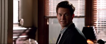 Movie still from “The Italian Job” (2003), directed by F. Gary Gray – A person wearing a suit and tie; Close Up shot, Over the shoulder angle