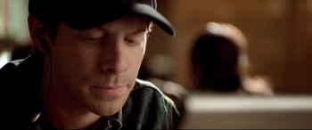 Movie still from “The Italian Job” (2003), directed by F. Gary Gray – A young man wearing a baseball cap looking at his cell phone; Extreme Close Up shot, High angle