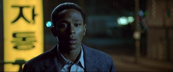 Movie still from “The Italian Job” (2003), directed by F. Gary Gray – A man in a suit and tie looking at the camera; Close Up shot, High angle