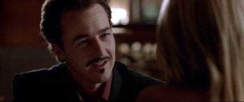 Movie still from “The Italian Job” (2003), directed by F. Gary Gray – A person wearing a suit and tie; Close Up shot, Over the shoulder angle