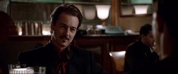 Movie still from “The Italian Job” (2003), directed by F. Gary Gray – A person wearing a suit and tie; Close Up shot, Over the shoulder angle