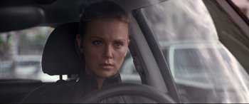 Movie still from “The Italian Job” (2003), directed by F. Gary Gray – A woman in a car looking at the camera; Close Up shot, Over the shoulder angle