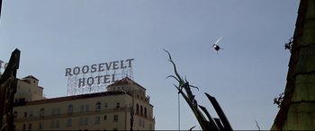 Movie still from “The Italian Job” (2003), directed by F. Gary Gray – An airplane flying over a hotel with a sign on top of it; Extreme Wide shot, Low angle