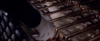 Movie still from “The Italian Job” (2003), directed by F. Gary Gray – A man that is putting gold bars together; Extreme Close Up shot, High angle