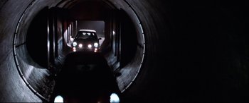 Movie still from “The Italian Job” (2003), directed by F. Gary Gray – A car is driving through a tunnel in the dark; Wide shot, High angle