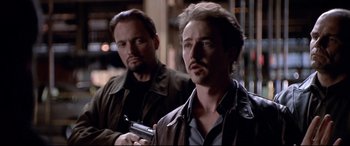 Movie still from “The Italian Job” (2003), directed by F. Gary Gray – A man holding a gun next to another man in a leather jacket; Close Up shot, Over the shoulder angle