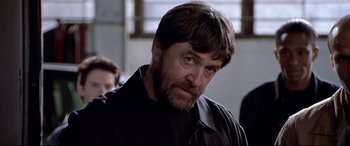 Movie still from “The Italian Job” (2003), directed by F. Gary Gray – A person wearing a black shirt; Close Up shot, Over the shoulder angle