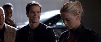 Movie still from “The Italian Job” (2003), directed by F. Gary Gray – A man and a woman in front of a black car; Close Up shot, Over the shoulder angle