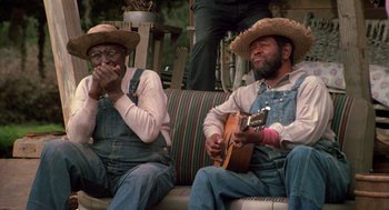 Movie still from “The Jerk” (1979), directed by Carl Reiner – A couple of men sitting next to each other on top of a couch; Medium shot, High angle