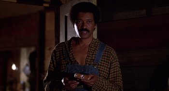 Movie still from “The Jerk” (1979), directed by Carl Reiner – A man holding a donut in his hands; Medium shot, Low angle