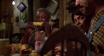 Movie still from “The Jerk” (1979), directed by Carl Reiner – A group of people sitting at a table eating food; Medium shot, Over the shoulder angle