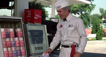 Movie still from “The Jerk” (1979), directed by Carl Reiner – A man in a white hat and white shirt is putting a drink in a drink dispenser; Medium shot, Over the shoulder angle