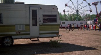 Movie still from “The Jerk” (1979), directed by Carl Reiner – An rv parked in the middle of a field with a ferris wheel in the background; Wide shot, Low angle