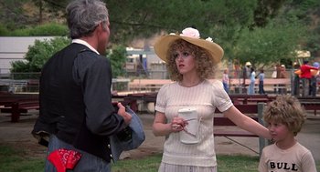 Movie still from “The Jerk” (1979), directed by Carl Reiner – A woman wearing a hat talking to a man in a park; Medium shot, Over the shoulder angle